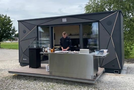 Gaulhofer Showküche im Einsatz. Die Mobile Küche und ein Koch sind auf dem Bild zu sehen.