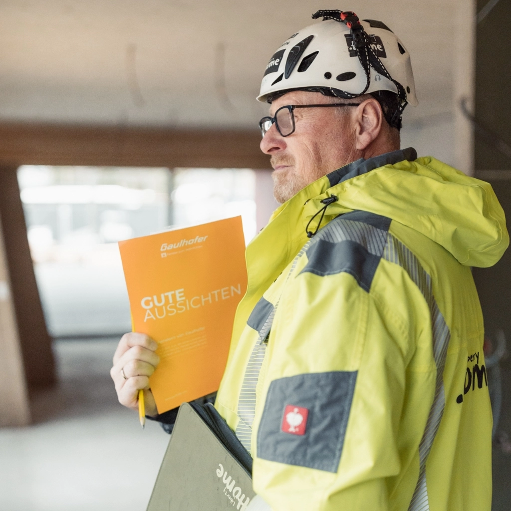 Bauleitung am Baufeld mit Sicherheitsausrüstung