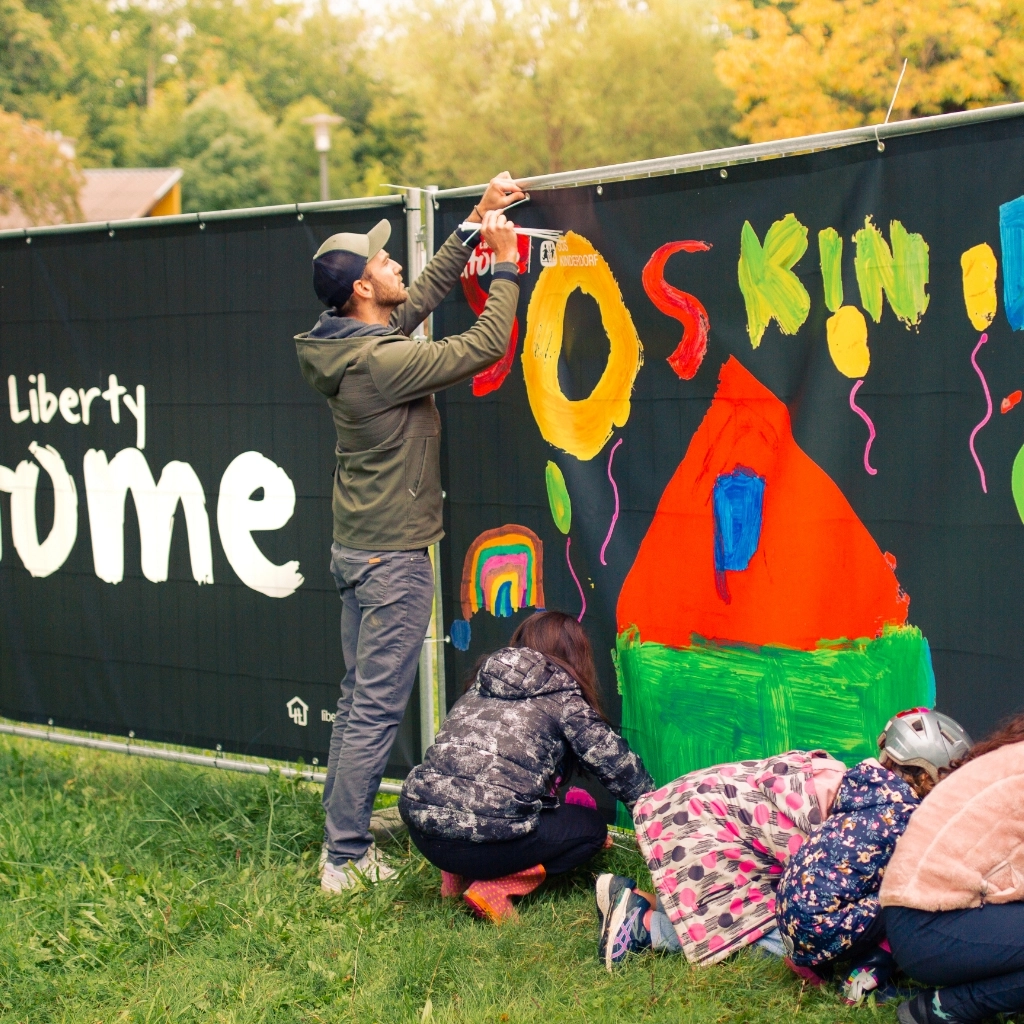 Markus Hörmanseder beim montieren der individuell gezeichneten Bauzäune im SOS-Kidnerdorf
